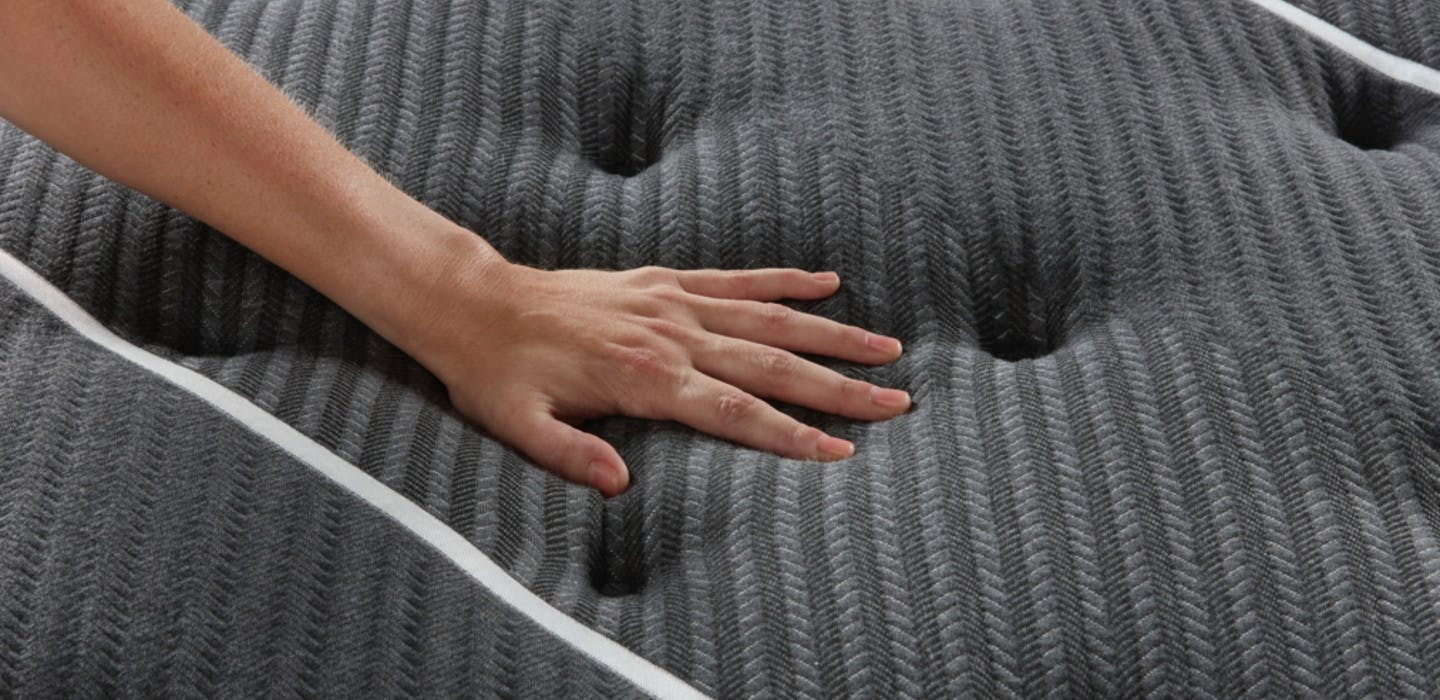 Close up of person putting their hand on the Beautyrest Black mattress